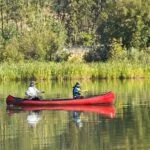 two men in a canoe on the lake participating in experiential therapy for addiction