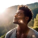 black man outdoors with his face toward the sun