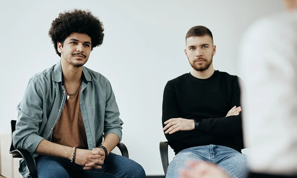 two men sitting beside each other in therapy