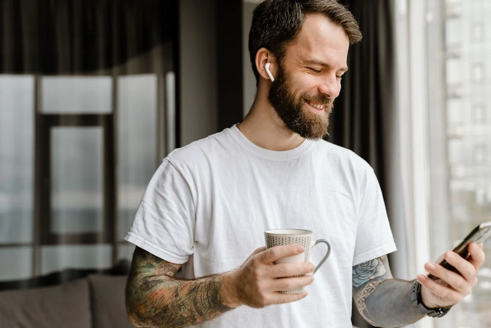 man holding a cup and talking on his phone