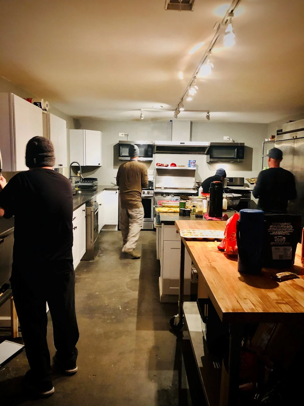 men in Spero kitchen doing a cooking workshop