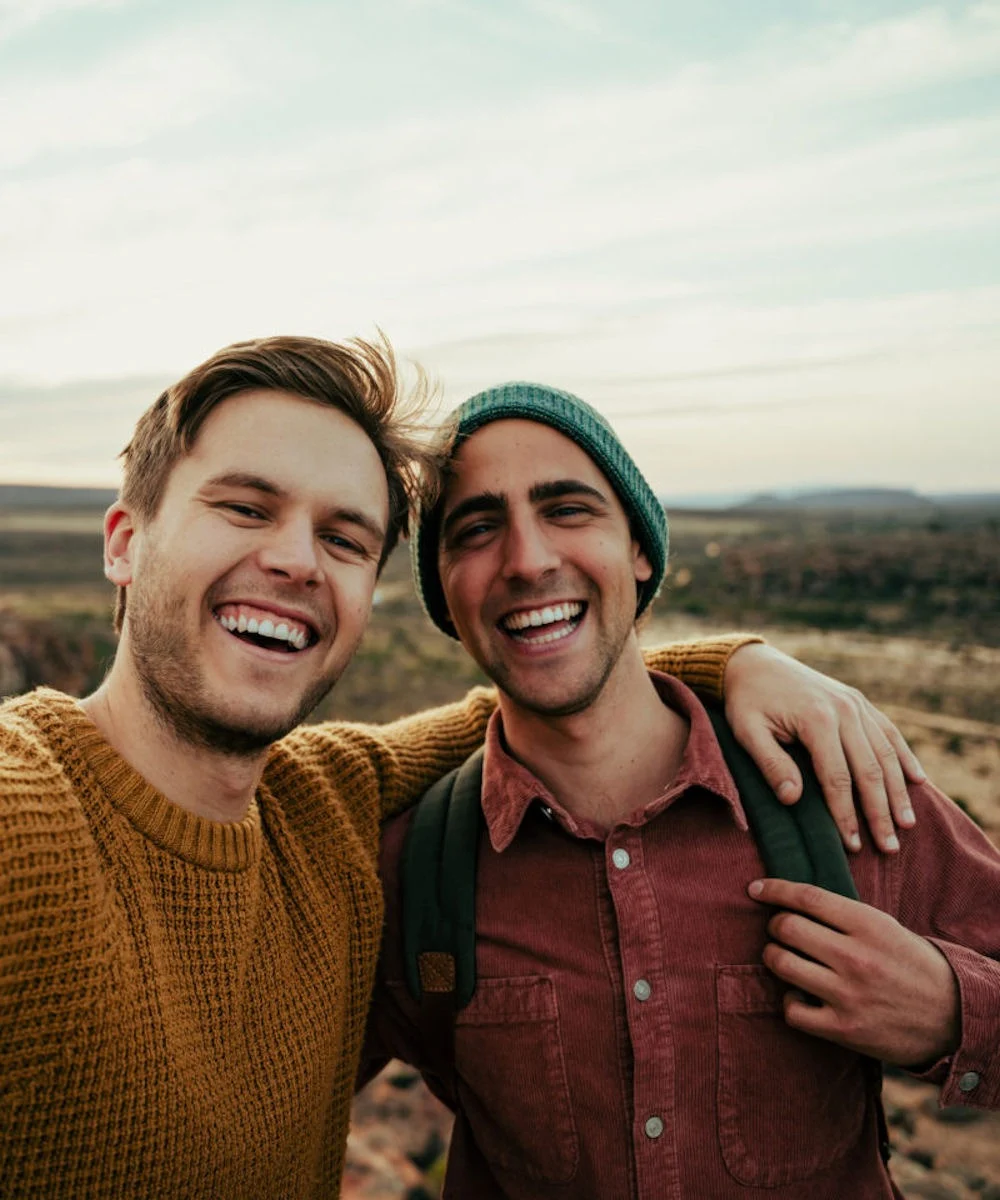 two smiling men outside