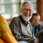 Elderly man sharing his experience in a Narcotics Anonymous meeting, fostering community support