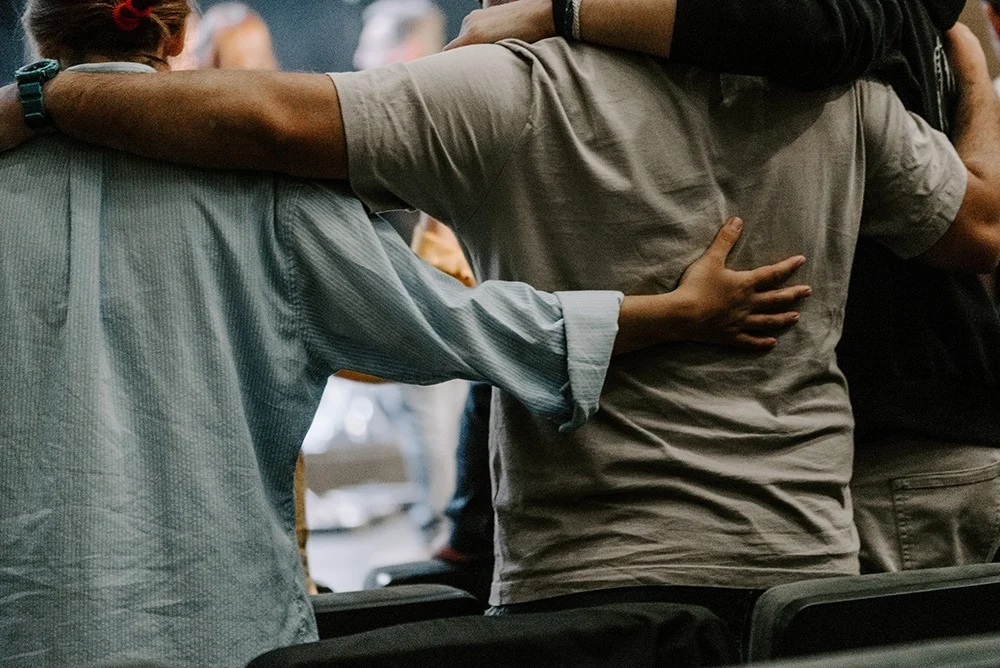 men embracing during group therapy