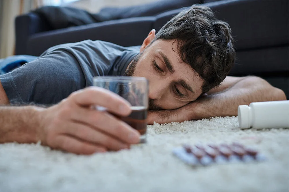 man with alcohol poisoning lying on the floor