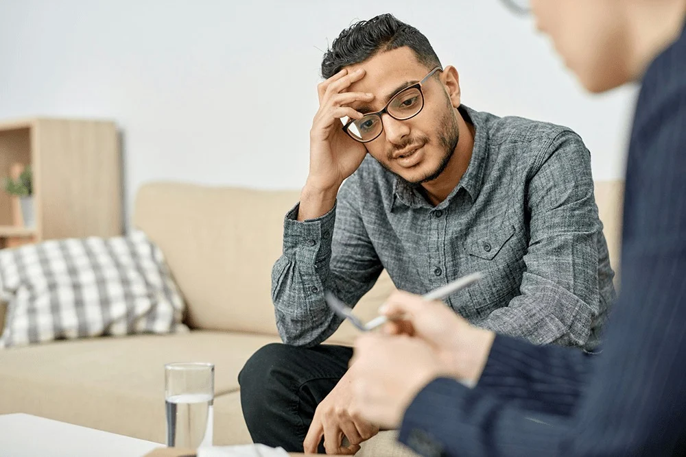 Man in a therapy session with a counselor, seeking professional support for addiction recovery.