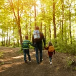 Father walking with his young son through the woods, representing breaking generational addiction and building a healthier future.