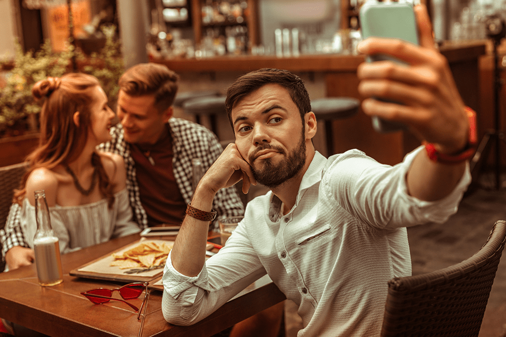 Man feeling isolated in a group, showing how men often struggle to express emotions or connect with friends.