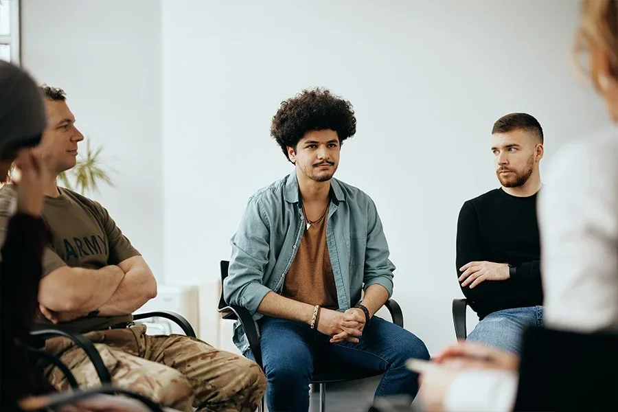 Men participating in group therapy for addiction recovery and safe, effective substance use treatment