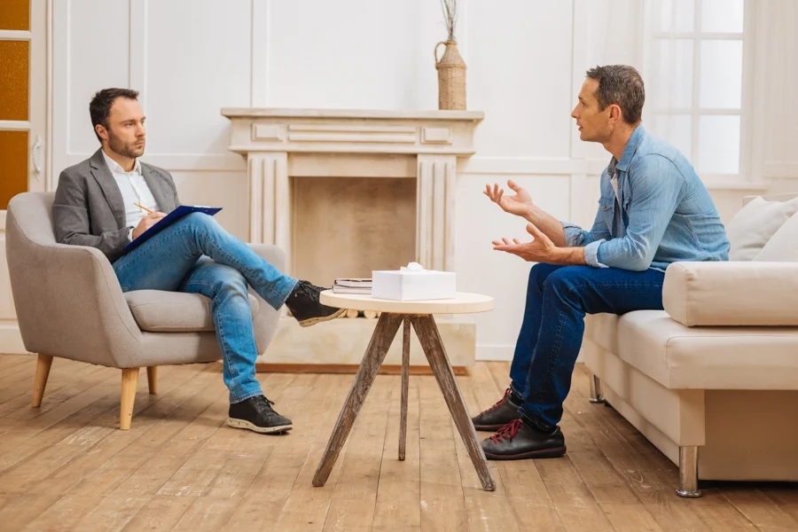 Supportive sponsor guiding a sponsee through recovery steps in a professional relationship