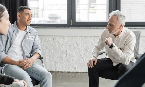 group of men sitting in a room having discussion