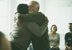 man and woman hugging in group therapy session