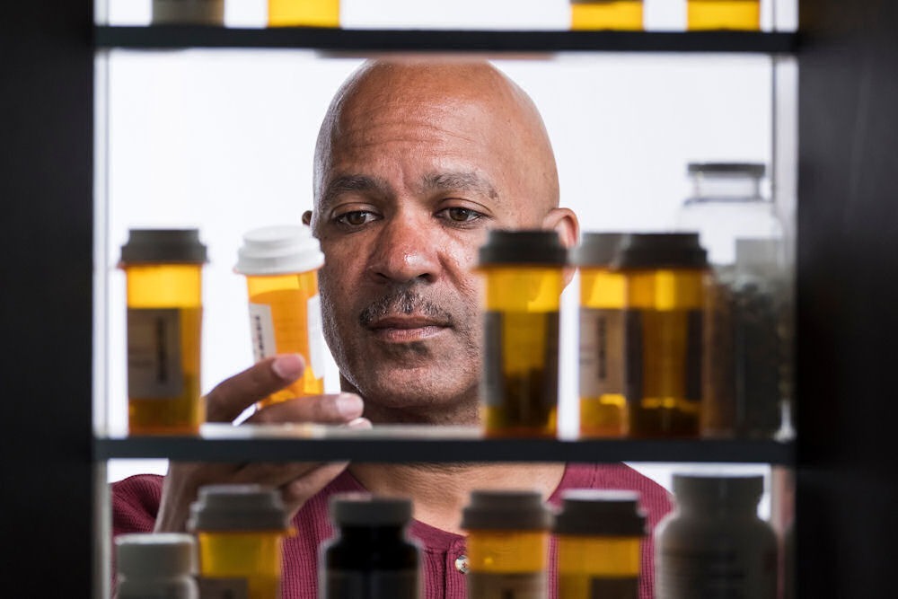 a man looking at a prescription bottle